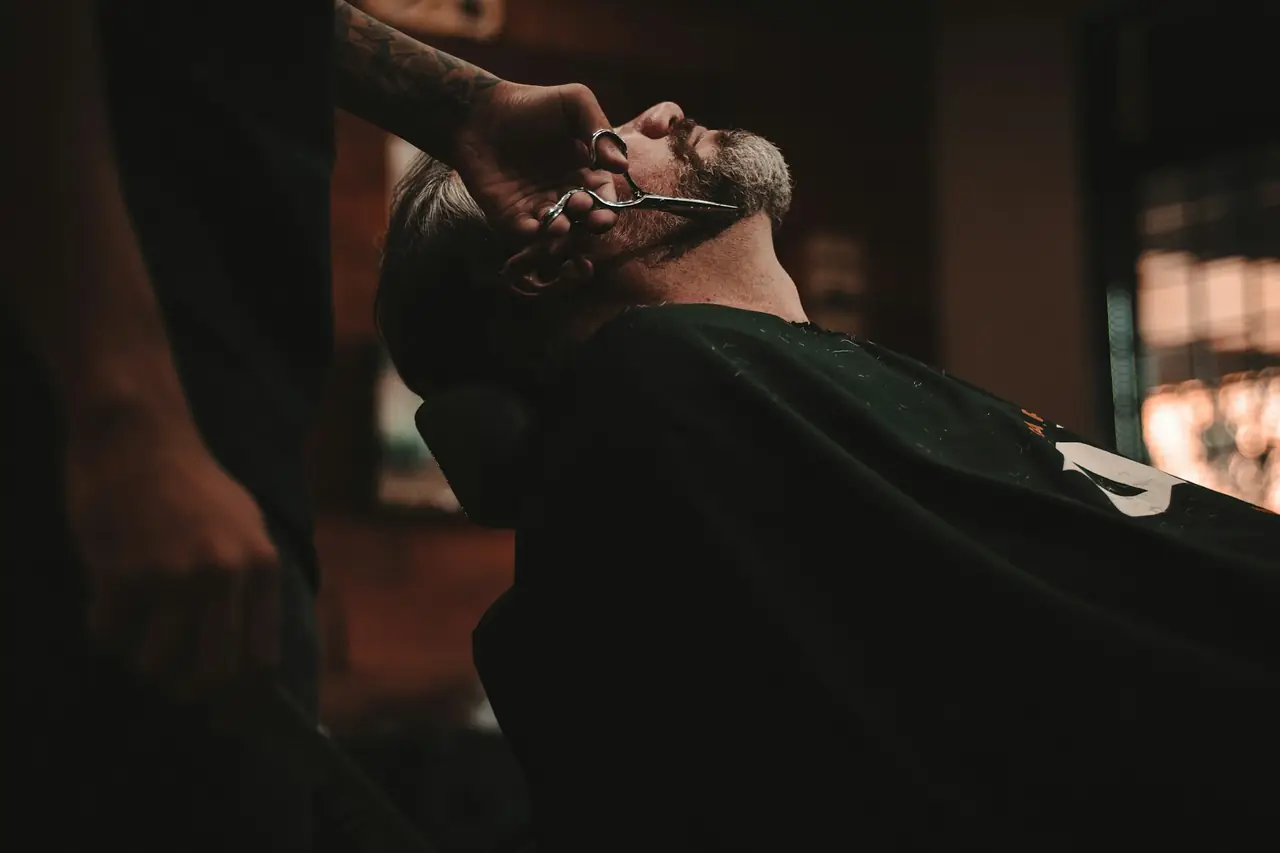 Barbeiro em atendimento na cadeira